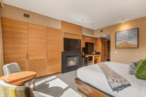 a bedroom with a bed with a fireplace and a television at Ski-In Ski-Out Resort Studio Steps from Slopes in Snowmass Village
