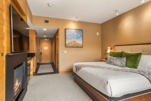 a hotel room with a bed and a flat screen tv at Ski-In Ski-Out Resort Studio Steps from Slopes in Snowmass Village