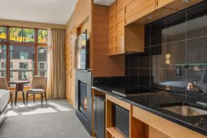 a kitchen with black counter tops and a fireplace at Ski-In Ski-Out Resort Studio Steps from Slopes in Snowmass Village