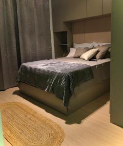 a large bed in a bedroom with a rug at Studio 406 Paranagua in Paranaguá