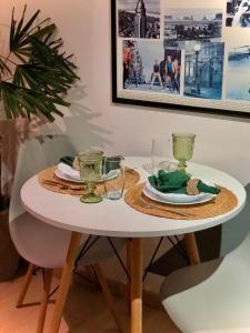 a white table with two plates and glasses on it at Studio 406 Paranagua in Paranaguá +15 photos