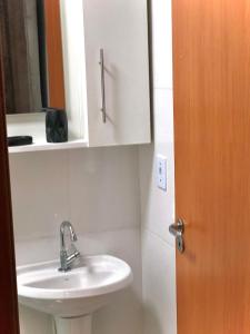 a bathroom with a sink and a mirror at Studio 406 Paranagua in Paranaguá