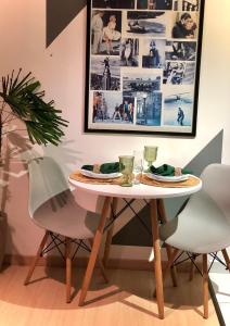 a table with two chairs and a plate of food on it at Studio 406 Paranagua in Paranaguá
