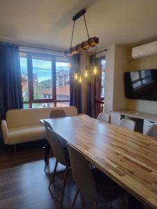a living room with a wooden table and a couch at Panorama View in Bansko