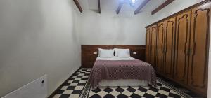 a bedroom with a bed and a checkered floor at La Barbacoa in Dos Pinos