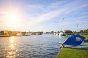 a boat is docked on a river with boats at Thurnefield Holiday Cottages in Potter Heigham