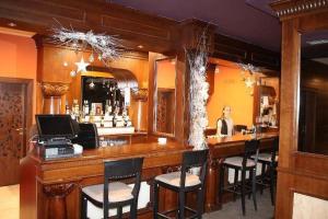 a bar with chairs and a woman sitting at it at Panorama View in Bansko