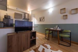 a living room with a flat screen tv and a table at Studio plein centre in Aix-les-Bains