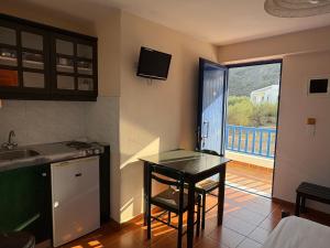 a kitchen with a table and a small kitchen with a balcony at Bay Watch in Karpathos