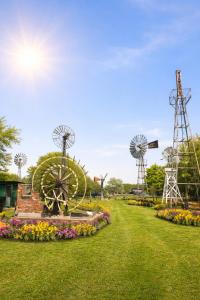 a park with windmills and a garden with flowers at Thurnefield Holiday Cottages in Potter Heigham