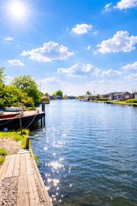 a river with a wooden dock on the side of it at Thurnefield Holiday Cottages in Potter Heigham +1 photo