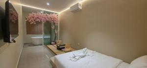 a bedroom with a bed and a bathroom with a tub at Ipoh Town Hotel by Serenity in Ipoh +47 photos