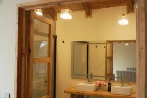 a bathroom with two sinks and two mirrors at NIDU Cabañas Boutique & Holística in Mineral del Monte