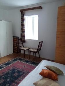 a bedroom with two chairs and a window at Grădina Zoriza in Buzău
