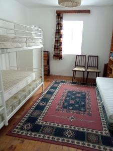 a bedroom with bunk beds and a rug at Grădina Zoriza in Buzău