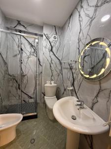 a bathroom with a sink and a shower and a toilet at Heming-way Hotel in Durrës +120 photos