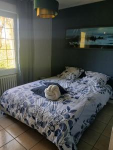 a bedroom with a bed with a blue and white comforter at Chambre d hote bucolique in Mahalon