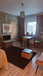 a living room with a table and a desk at Cozy Studio in Kouvola