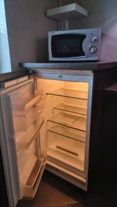 an open refrigerator with a microwave on top of it at Cozy Studio in Kouvola +9 photos
