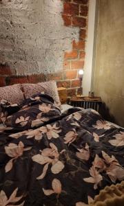 a bed in a room with a brick wall at Cozy Studio in Kouvola