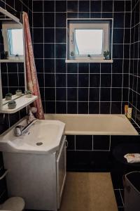 a bathroom with a tub and a sink and a bath tub at Berlin Home by RentALL in Gheorgheni