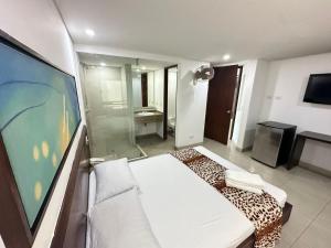 a room with a bed and a television and a bathroom at Hotel Via 45 Centro in Medellín +37 photos