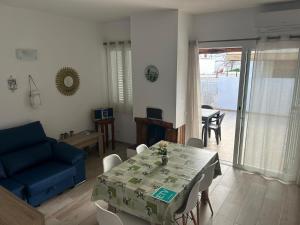 a living room with a table and a blue couch at Can Fede in Cala Tarida