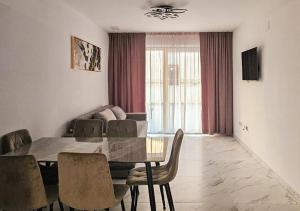 a dining room with a table and chairs and a couch at Luxury Beachfront Family Apartment in La Pineda