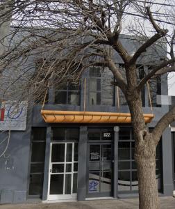a building with a tree in front of it at Departamento centro Gral Roca in General Roca