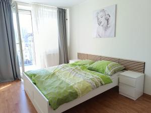 a bedroom with a bed with green sheets and a window at Central apartment in Staré Mesto