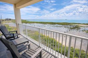 a porch with two chairs and a view of the beach at Tortuga Bay home in South Padre Island
