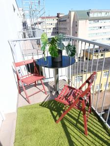 two chairs and a table with a potted plant on a balcony at Central apartment in Staré Mesto