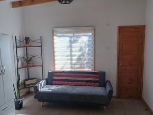 ein Wohnzimmer mit Sofa und Fenster in der Unterkunft Cabaña Peralillo in Vicuña