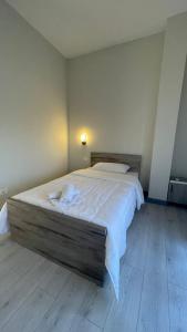 a bedroom with a large bed with white sheets at Hotel RADOJA in Shkodër