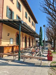 a group of benches in front of a building at 3sine - Ihr besonderer Gasthof im Bahnhof Deisenhofen in Oberhaching