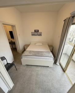 a small bedroom with a bed and a chair at Lux Apartment City View in Larnaca