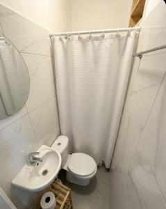 a white bathroom with a toilet and a sink at Lux Apartment City View in Larnaca