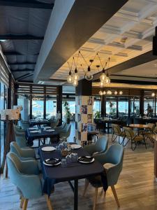 a restaurant with tables and chairs and a bar at Heming-way Hotel in Durrës