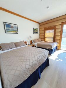a bedroom with two beds and a window at Bear's Claw Lodge in Cache Creek