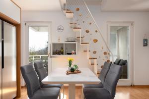 a dining room with a table and chairs and a staircase at SeaView Lovran in Lovran