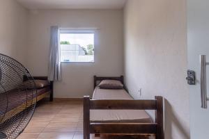 a small room with two beds and a window at Apartamento 4 quartos com Wi Fi e Garagem in Pará de Minas