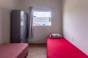 a bedroom with a red carpet and a window at Apartamento 4 quartos com Wi Fi e Garagem in Pará de Minas