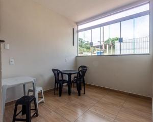 a dining room with a table and chairs and a window at Apartamento 4 quartos com Wi Fi e Garagem in Pará de Minas