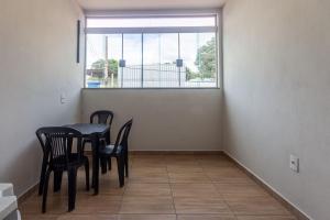 a dining room with a table and chairs and a window at Apartamento 4 quartos com Wi Fi e Garagem in Pará de Minas