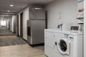 a laundry room with a refrigerator and washing machines at City Express by Marriott Bemidji in Bemidji