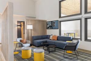 a living room with a blue couch and chairs at City Express by Marriott Bemidji in Bemidji