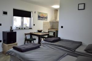 a room with two beds and a table and a kitchen at MM Studio in Donji Miholjac