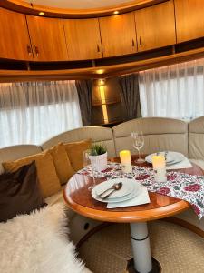 a table in a living room with a couch at Nordic Dream Camper 1 in Syfteland