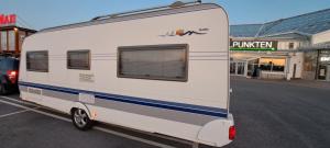 a white trailer parked in a parking lot at Nordic Dream Camper 1 in Syfteland +5 photos