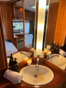 a bathroom with a sink and a mirror at Nordic Dream Camper 1 in Syfteland